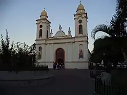 A large church surrounded by palm trees on both sides