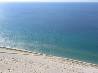 Lake view from the Sleeping Bear Dunes National Lakeshore, with people climbing uphill