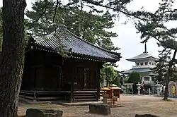 Large stones set in the ground in front of temple buildings.