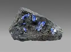Bright blue scorodite crystals on brown-black beudantite, 8 x 5 x 3&nbsp;cm.