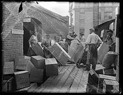 Showing cases of kauri gum being loaded on to a dray, taken July 1905