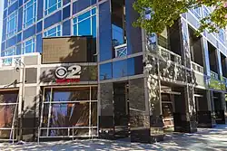 KUTV signage on the exterior of the ground floor of a skyscraper. Windows of the streetside studio are also visible.