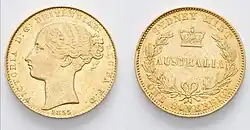 A gold coin, with a left-facing bust of Queen Victoria wearing ribbons in her hair and an inscription dated 1855 on the obverse, and symbols and an inscription indicating the Sydney Mint, Australia, one sovereign on the reverse.