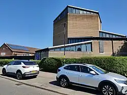 Modernist brick and concrete building, with older brick building to one side