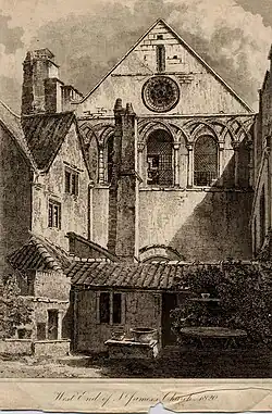 Monochrome illustration of the west end of St James' church, published in 1820. The image shows the parts of the priory stonemasonry incorporated into the church facade and a jumble of non-ecclesiastical buildings in the foreground including a tall chimney.