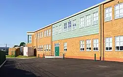 A picture taken outside depicting the rear of the school's extension with a blue sky overhead