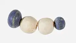 String of beads; 3650–3100 BC; lapis lazuli (the blue beads) and travertine (the white beads) (Egyptian alabaster); length: 4.5 centimetres (1.8&nbsp;in); by Naqada II or Naqada III cultures; Metropolitan Museum of Art (New York City)