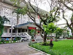 A white modernist building surrounded by trees