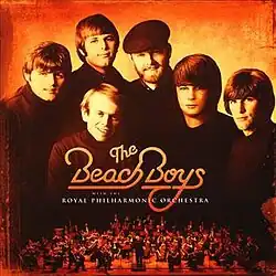 A sepia-toned photo of the Beach Boys with the orchestra pit below them