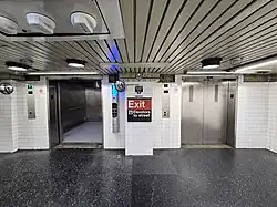 Two of the elevators leading from the Clark Street Passage to the ground level. There is a sign in the middle, indicating that the elevators lead to the street level/station exit.