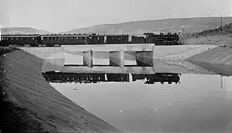 Steam powered passenger train on bridge