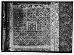 Close-up of the decorative details, with one of the inscriptions containing a craftsman's signature