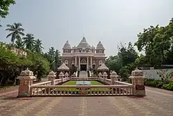 A picture of the temple (The Universal Temple at Sri Ramakrishna Math, Chennai). Picture taken on 10/27/2024 by Sundar Karthikeyan. Shows the front facade with the leading steps and the small enclave with a description of the mission.