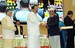 Vice President, Shri M. Venkaiah Naidu handing away the Prime Minister Shram Awards to another person.