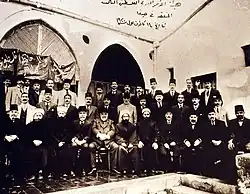Large group of men—some seated, some standing