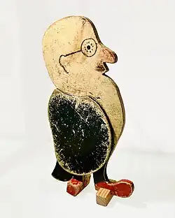 Small wooden toy depicting a bearded man with round glasses.