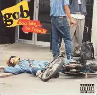 A picture of a biker in a full body jacket and biking helmet on the ground after a biking accident. There are also 2 other people visible and text saying the band's name and album title. The back of the booklet has a picture of that same biker with crutches.