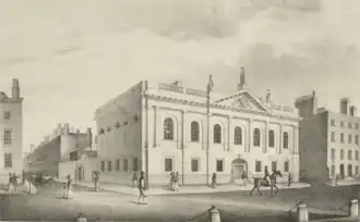 Neoclassical facade of the Royal College of Surgeons in Ireland with people walking