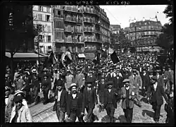 Crowd flying tricolor flags up a boulevard in northern Paris.