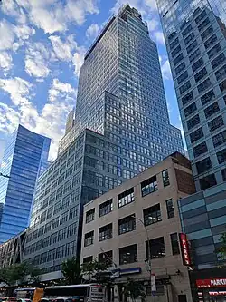 330 West 42nd Street seen from just east of Ninth Avenue. There is a low-rise brick building and a glass tower to the right, and another glass tower to the left.