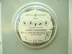 Circular glass case, covers a row of five small dials, each with a pointer