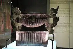 bronze vessel with flamboyant handles but having its body decorated only with a vertical stripe pattern