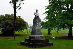 Carved bust of a man on a plinth in a lawn