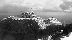 The Echo Mountain Promontory (ca. 1896) after a snowfall, and the White City resort of the Mount Lowe Railway as seen from a higher spot on the ridge and overlooking Altadena, CA. Buildings viewed from left to right: The Echo Chalet, Echo Mountain House, Incline Powerhouse, Dormitories, and Car Barn. Behind the car barn, note an inflatable reservoir for the storage of hydrogen gas produced in Pasadena and piped some 8.5 miles (13.7&nbsp;km) to Echo. Echo Mountain is also known for its incredible echoes.