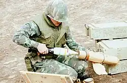 Fuzed 81&nbsp;mm white phosphorus mortar shell in 1980. Note spelling of "fuze" on adjacent boxes