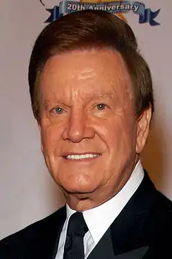 Television host Wink Martindale, wearing a black suit and tie.