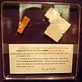 Wright Flyer wood, fabric, and a note by Orville Wright taken aboard and recovered from Space Shuttle Challenger's 1986 flight STS-51-L, which exploded soon after liftoff