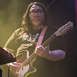 McNew playing 12-string guitar onstage