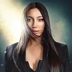 The cover artwork for "New Day Will Rise". The cover features a portrait of Yuval Raphael amidst a cloudy background, with one ray of sunlight breaking through the clouds and illuminating her.