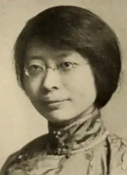 A young Chinese woman wearing eyeglasses and a high-collared silk blouse