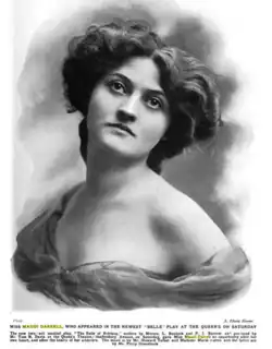 Photograph of a young white woman, in a glamorous pose, with bare shoulders and voluminous wavy hair.
