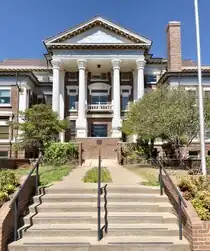 The front side of a brick building with white columns.