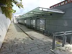 Fietsenrekken tegen de achterwand van een afdak.