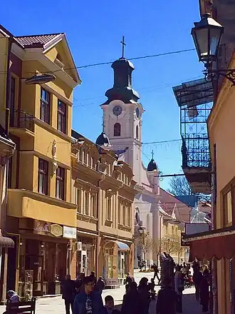 Doorkijkje langs winkels en balkons richting de Sint-Joriskerk