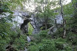 Karstbrug over de Koeperlja en een kleine waterval.
