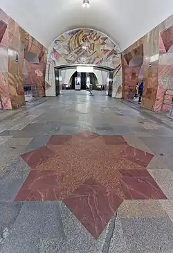 De oostelijke roltrappen en de vloer met anjers