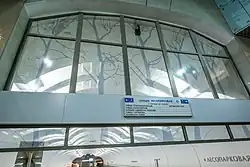 De glazenwand boven de kopsekant van het perron