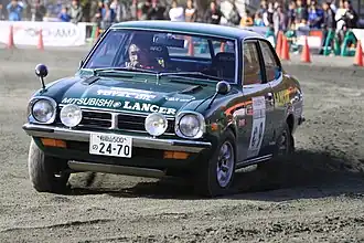 Shinozuka achter het stuur van een Mitsubishi rallywagen (2008)