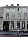 Huis met 19e-eeuwse, eenvoudige gewitte gevel, waarachter, blijkens het metselwerk, nog delen van het daar in 1591 gevestigde kartuizerklooster schuilgaan