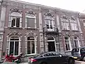 Huis met pompeuze gevel met weelderige versieringen in hardsteen in de trant van de antwerpse neobarok