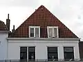 Pand met forse lijstgevel onder fraaie kap met topschoorsteen. Dakkapel