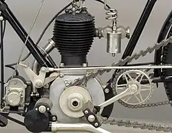 De linkerkant van het blok met de ontstekingsmagneet, aanfietstrapper en -ketting, voetsteun en pedaal voor de naafversnelling