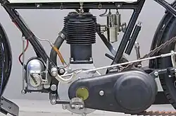 De linkerkant van de motor met de ontstekingsmagneet, het rempedaal en de aluminium kettingkast voor de primaire aandrijving.