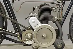 De 225cc-motor met het grote buitenliggende vliegwiel en de aandrijfriem naar het achterwiel.