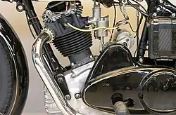 De linkerkant van het motorblok met de buitenliggende klepveren en het deksel van de primaire transmissie. In de "bult" zat de aandrijving van de magdyno. Linksonder is het oliecompartiment van het carter zichtbaar. Linksboven een van de lussen voor de aansluiting van een zijspan.