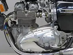 Aan de linkerkant het deksel van de primaire transmissie en het rempedaal.